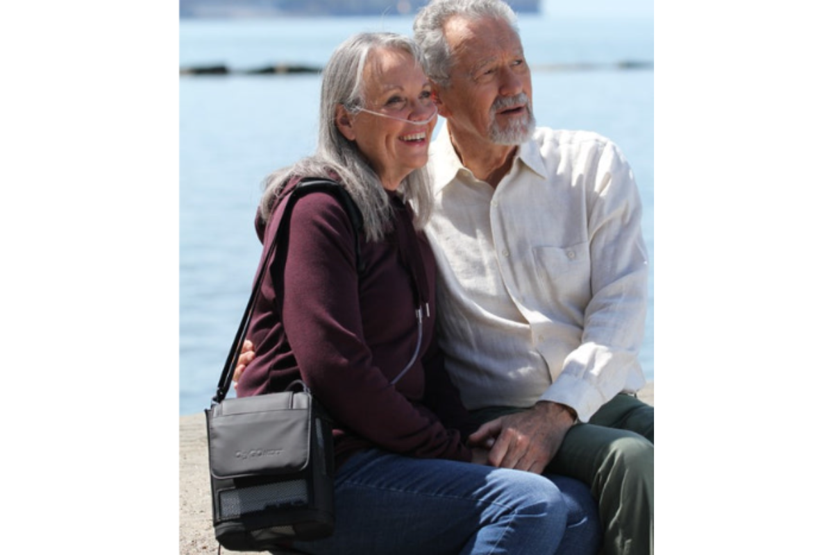 Portable oxygen concentrator in a bag worn by a woman